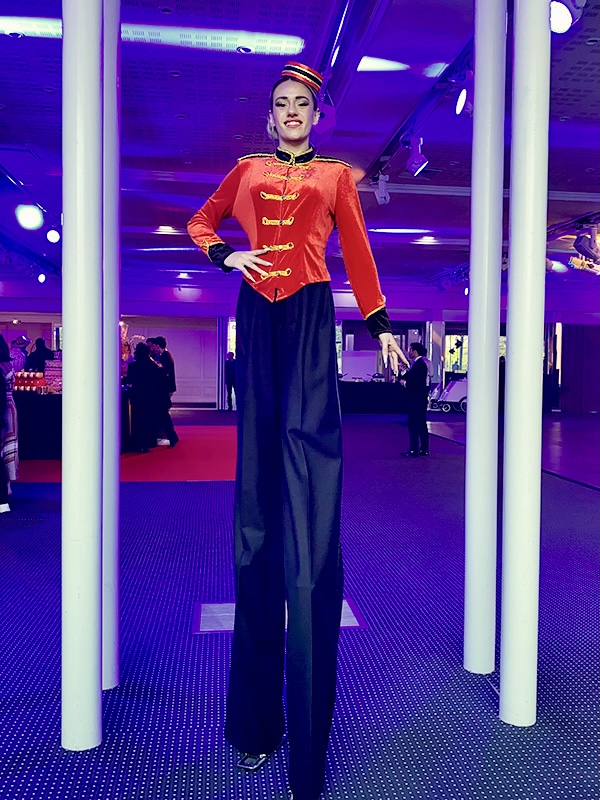 �chassi�re Groom en costume rouge et noir sur �chasses lors d'une r�ception �v�nementielle haut de gamme en int�rieur.