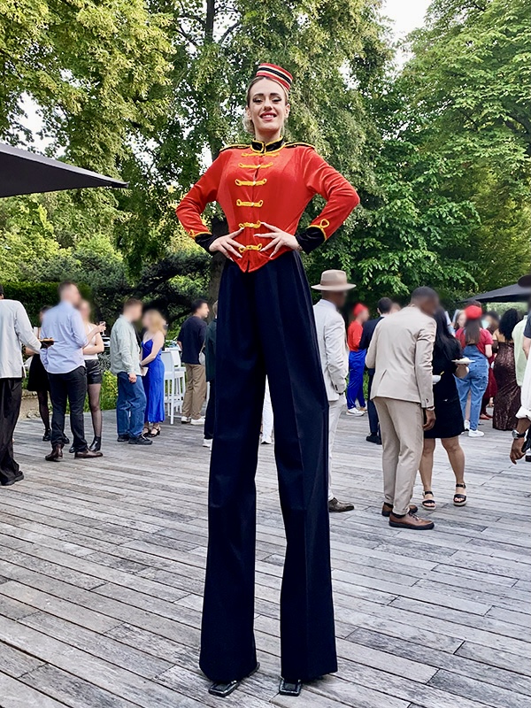 �chassi�re Groom en costume rouge accueillant les invit�s lors d'un cocktail d'entreprise en ext�rieur.